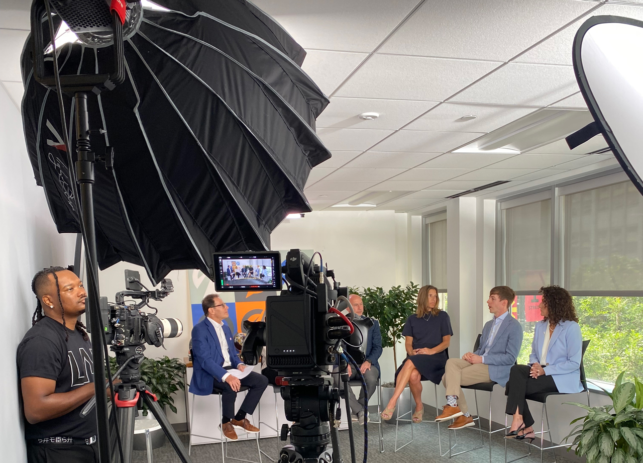 A Camera Crew Shoots An Interview In An Office Setting.